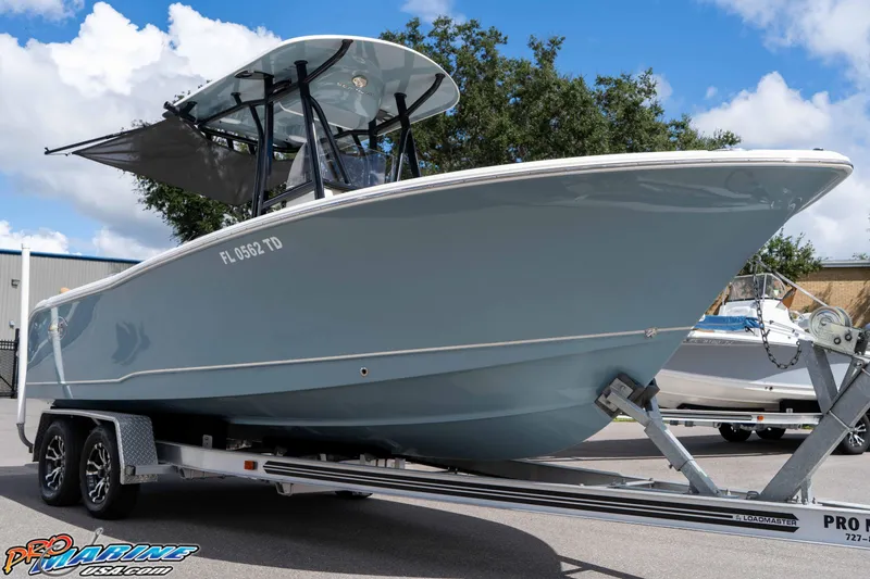 Slide: The Image of 2022 Sea Hunt Ultra 229 boat on trailer, parked outdoors under blue sky. - 15