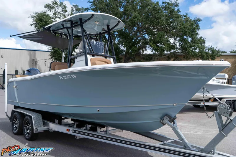 Slide: The Image of 2022 Sea Hunt Ultra 229 boat on trailer, parked outdoors under a clear sky. - 17