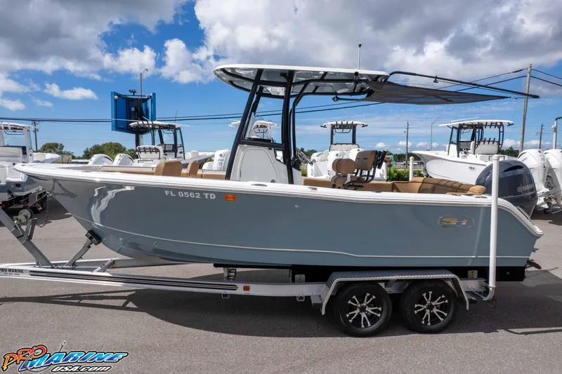 Slide: The Image of 2022 Sea Hunt Ultra 229 boat on trailer under cloudy sky at dealership. - 18