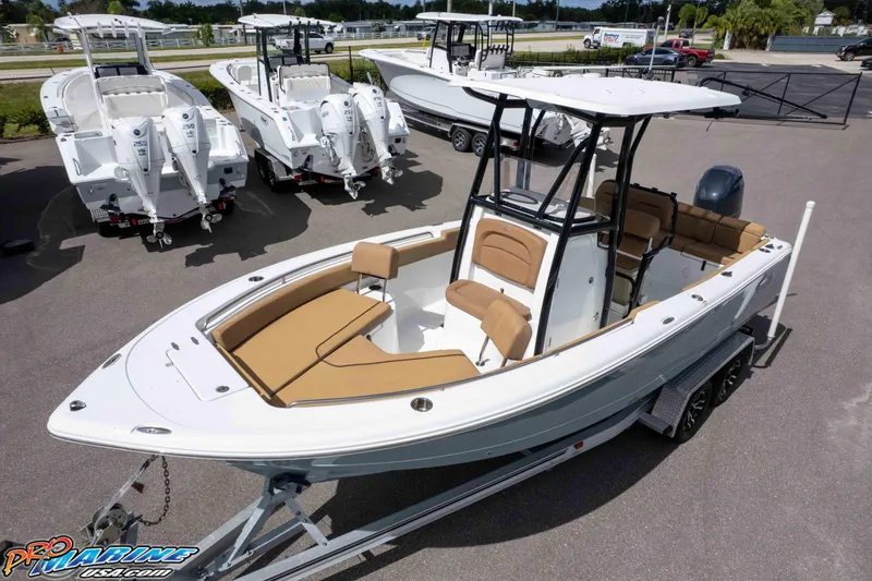 Slide: The Image of 2022 Sea Hunt Ultra 229 boat on trailer, with tan seating and T-top, in dealership lot. - 26