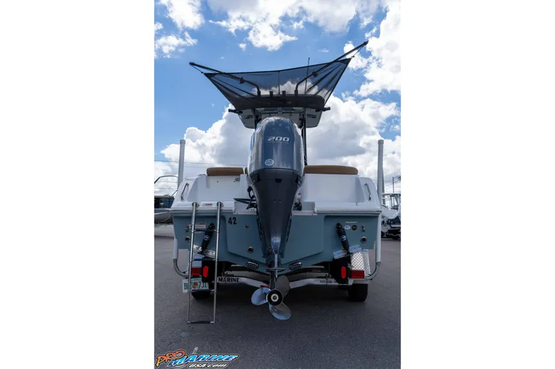 Slide: The Image of 2022 Sea Hunt Ultra 229 boat with powerful outboard motor, parked under a cloudy sky. - 35