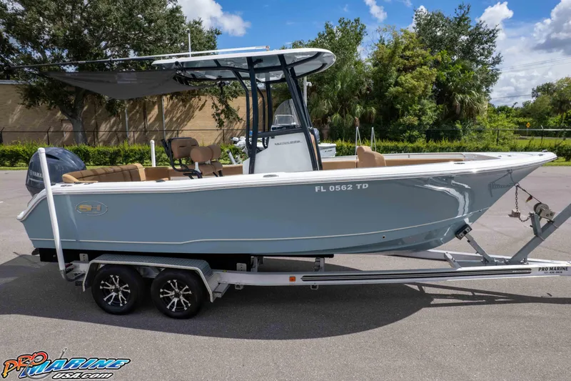 Slide: The Image of 2022 Sea Hunt Ultra 229 boat on trailer, parked outdoors under clear sky. - 4