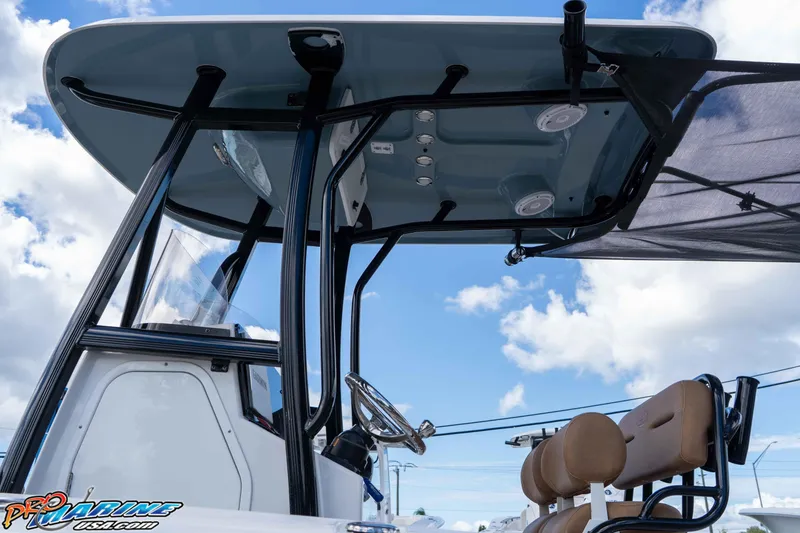 Slide: The Image of 2022 Sea Hunt Ultra 229 boat interior with T-top and seating against blue sky. - 44