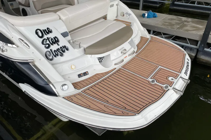 Slide: The Image of 2015 Crownline 335 SS boat with cushioned seating and teak-style flooring. - 11