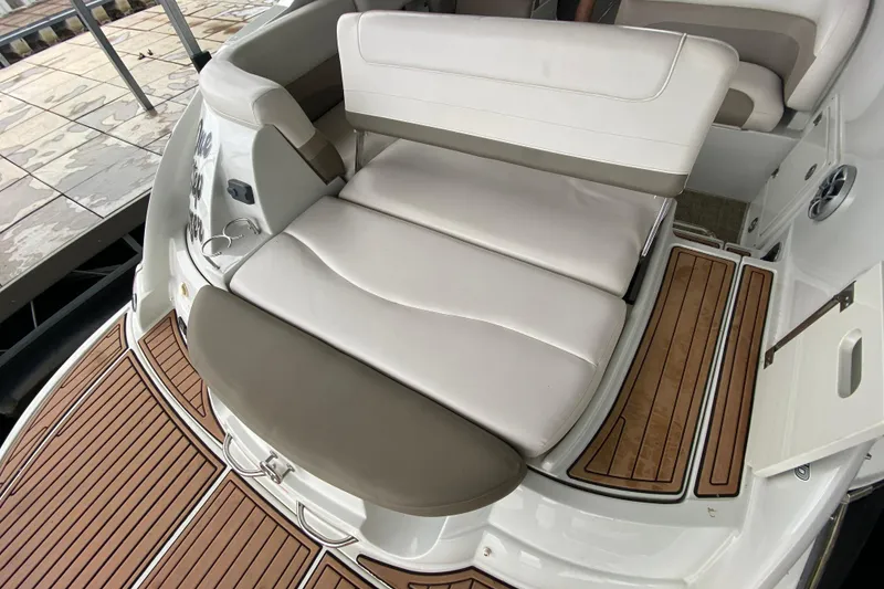Slide: The Image of 2015 Crownline 335 SS boat interior with beige seating and carpeted flooring. - 13