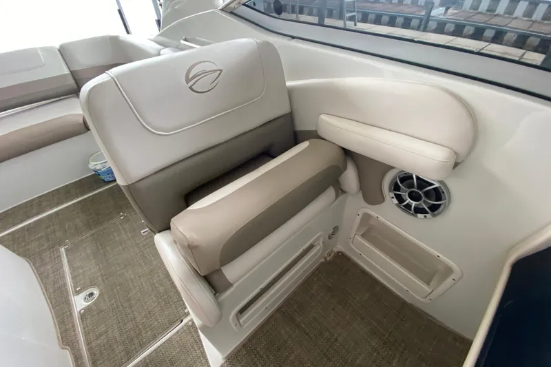 Slide: The Image of 2015 Crownline 335 SS boat interior with beige seating and speaker. - 23