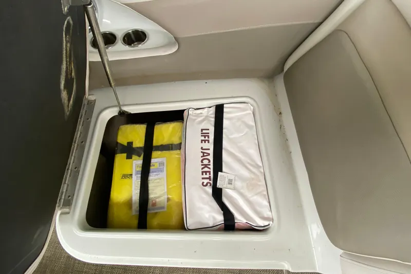 Slide: The Image of Storage compartment with life jackets on a 2015 Crownline 335 SS boat. - 37