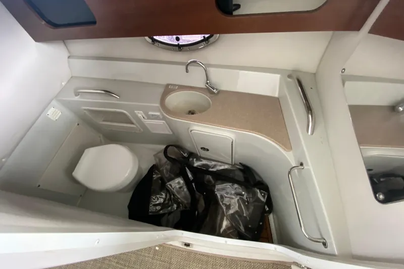 Slide: The Image of 2015 Crownline 335 SS boat bathroom with sink, mirror, and toilet. - 40