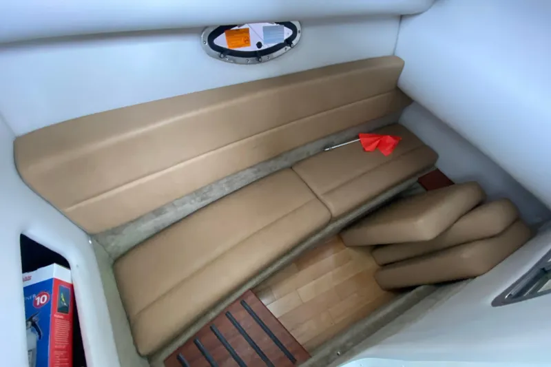 Slide: The Image of Interior of 2015 Crownline 335 SS boat with beige seating and wall storage. - 42