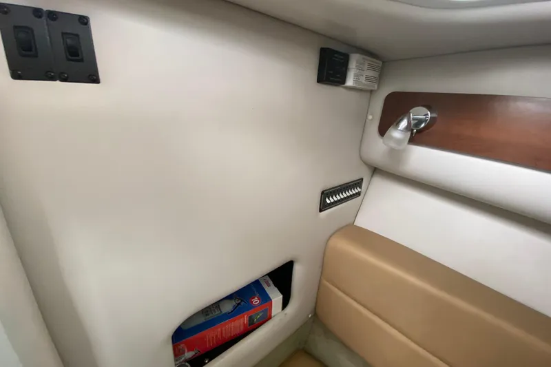 Slide: The Image of Interior cabin of 2015 Crownline 335 SS boat with tan seating and small window. - 43
