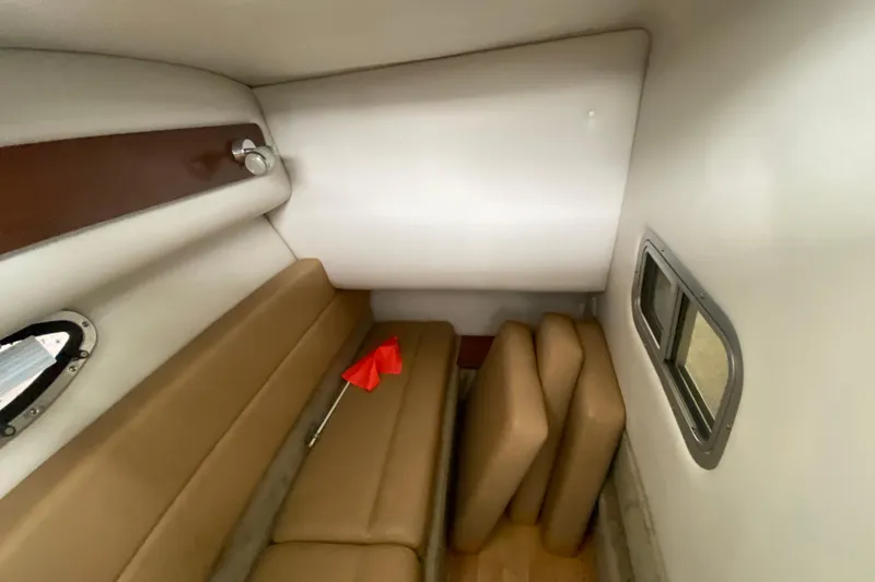 Slide: The Image of Open storage compartment in 2015 Crownline 335 SS boat, containing black fabric and metal poles. - 44