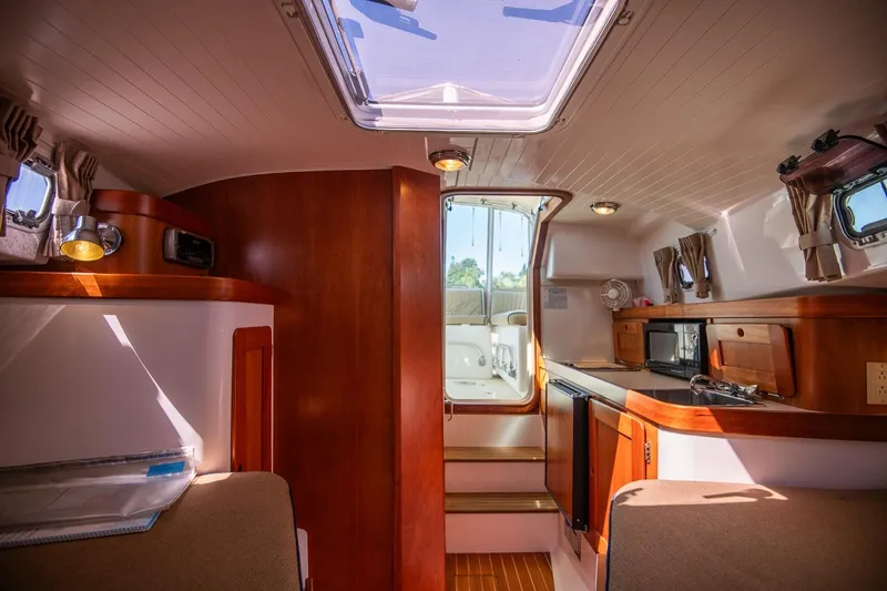 Slide: The Image of Interior of 2005 Hunt Yachts Surfhunter 29, featuring wood finishes and natural light. - 22
