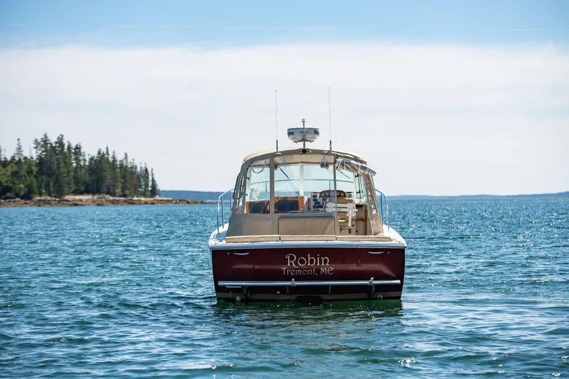 Slide: The Image of 2005 Hunt Yachts Surfhunter 29 on serene water, distant forested shoreline. - 29