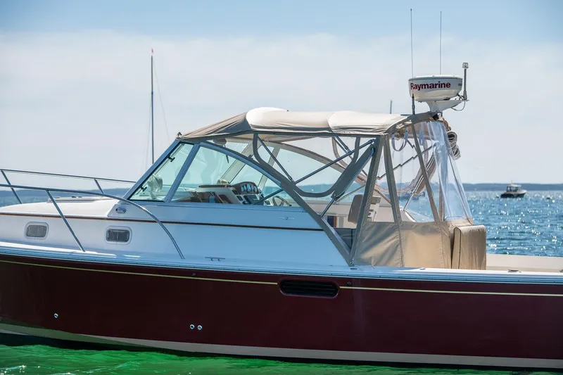 Slide: The Image of 2005 Hunt Yachts Surfhunter 29 on clear blue water, featuring sleek design and Raymarine equipment. - 30