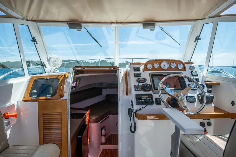 Slide: The Image of 2005 Hunt Yachts Surfhunter 29 cockpit with steering wheel, navigation instruments, and cabin entrance. - 12