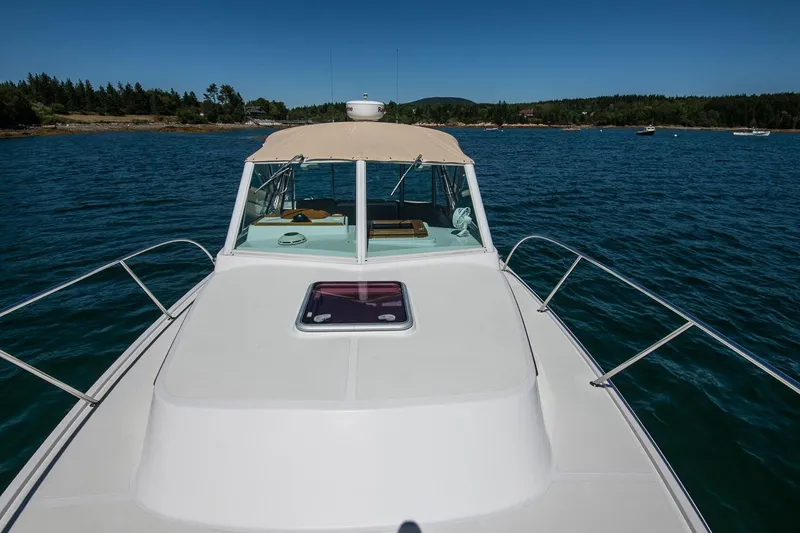 Slide: The Image of 2005 Hunt Yachts Surfhunter 29 on calm water, showcasing sleek design and spacious deck. - 17