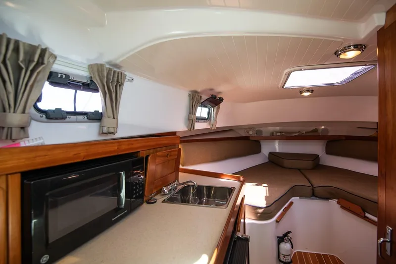 Slide: The Image of 2005 Hunt Yachts Surfhunter 29 interior with kitchenette and cozy seating area. - 18