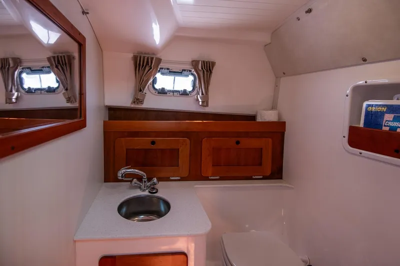 Slide: The Image of 2005 Hunt Yachts Surfhunter 29 bathroom with sink, mirror, and storage cabinets. - 20