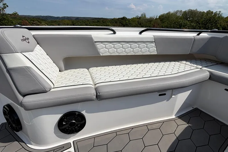 Slide: The Image of 2022 Fountain 38 SC boat interior with hexagonal-patterned seating and scenic background. - 11