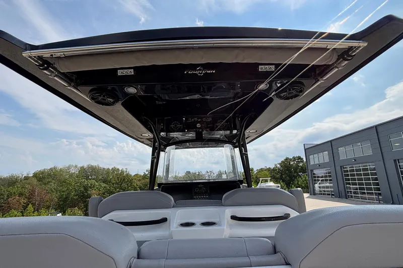 Slide: The Image of 2022 Fountain 38 SC boat interior with canopy, speakers, and seating under a clear sky. - 22