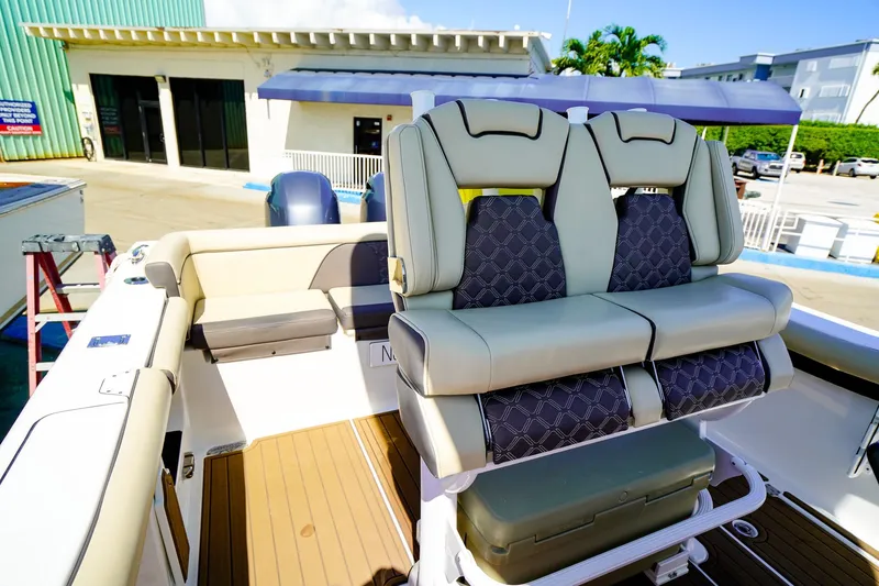 Slide: The Image of 2021 Tidewater 256 LXF boat interior with cushioned seating and dual engines. - 14