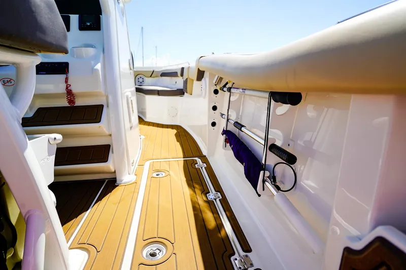 Slide: The Image of 2021 Tidewater 256 LXF boat interior with teak flooring and fishing rod holders. - 16