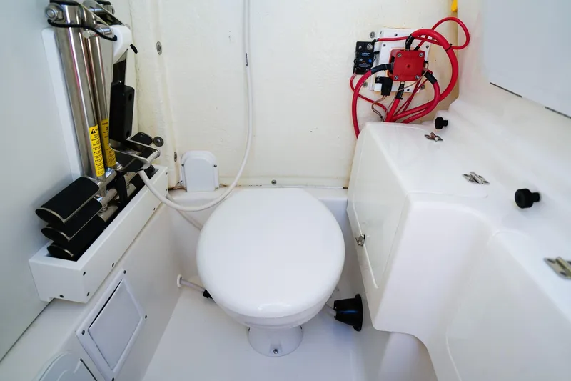 Slide: The Image of 2021 Tidewater 256 LXF boat interior with toilet and equipment storage. - 18