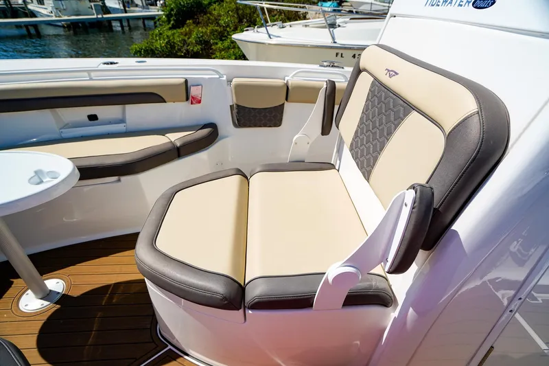 Slide: The Image of 2021 Tidewater 256 LXF boat interior with cushioned seating and table. - 21
