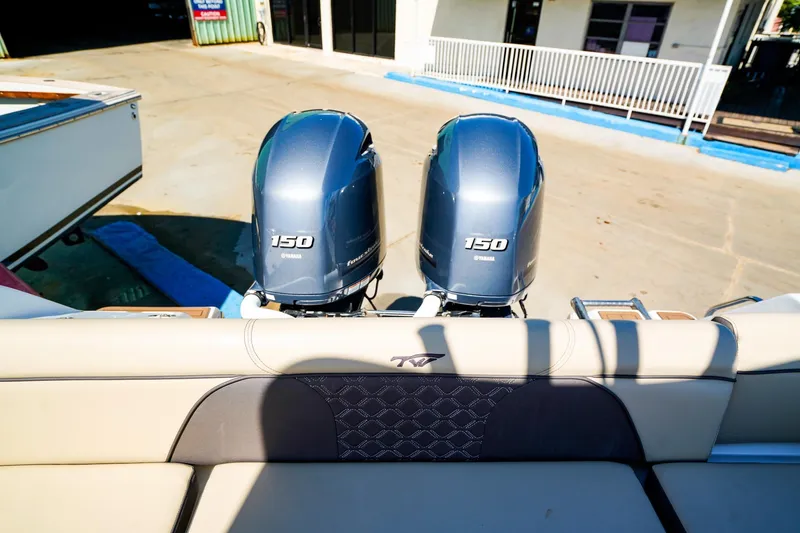 Slide: The Image of Tidewater 256 LXF 2021 boat with dual Yamaha 150 engines, docked outdoors. - 6