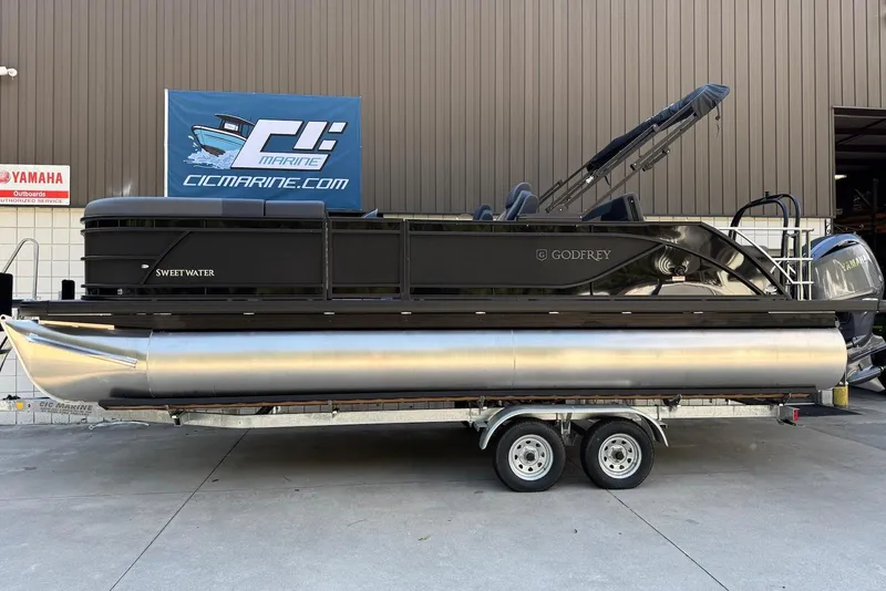 Slide: The Image of 2026 Godfrey SWEETWATER 2286 SFL pontoon boat on trailer at dealership. - 2