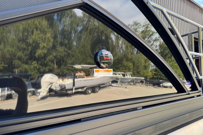 Slide: The Image of Reflection on Godfrey SWEETWATER 2286 SFL boat window, showcasing outdoor scenery and parked boats. - 38