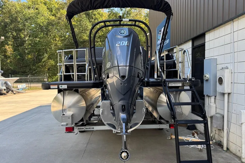 Slide: The Image of 2026 Godfrey SWEETWATER 2286 SFL pontoon boat with powerful outboard motor, parked outdoors. - 4