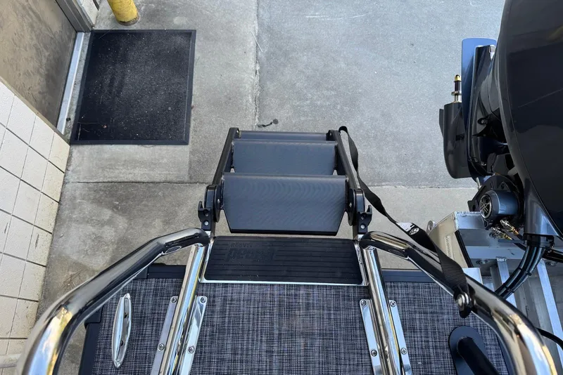 Slide: The Image of Godfrey SWEETWATER 2286 SFL boat ladder and engine, 2026 model, on concrete surface. - 5