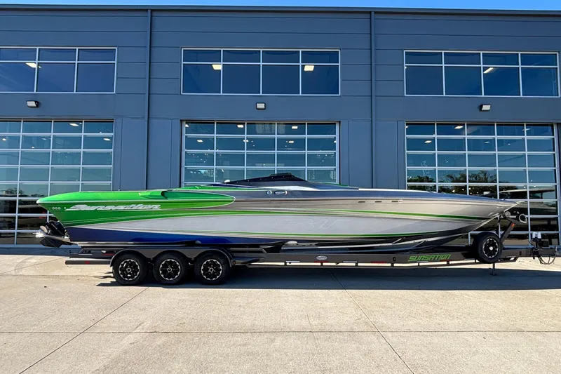 The Image of 2013 Sunsation 36 XRT speedboat with green and silver design, parked on a trailer. - 0
