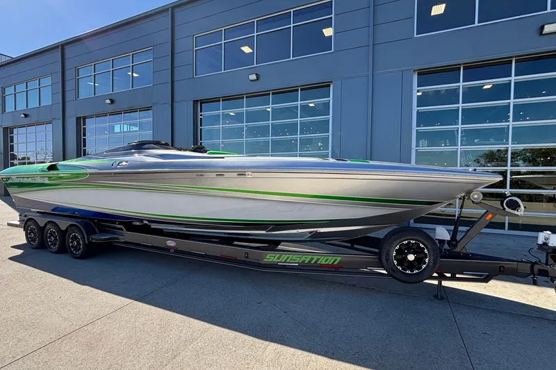 Slide: The Image of 2013 Sunsation 36 XRT boat on trailer, parked outside a modern building. - 45