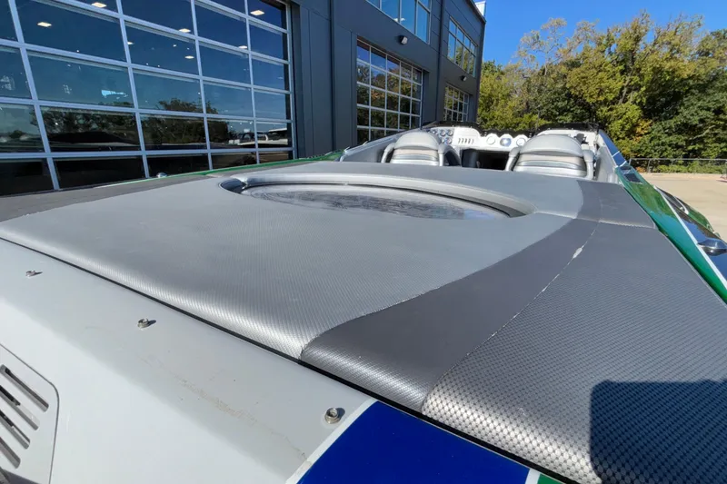 Slide: The Image of 2013 Sunsation 36 XRT boat with sleek design, parked near modern building. - 8