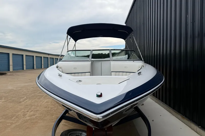 Slide: The Image of 2005 Cobalt 240 boat with canopy, parked near storage units. - 3