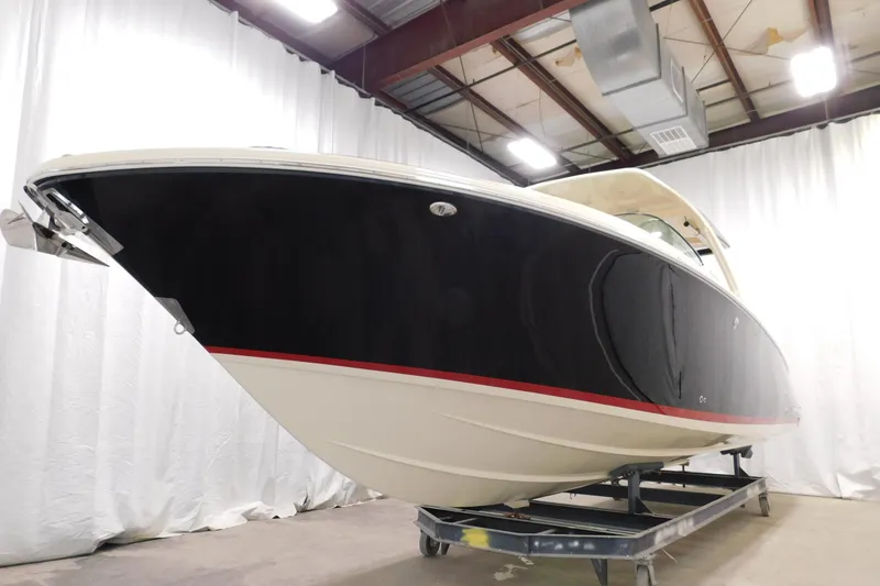 Slide: The Image of 2021 Chris-Craft Launch 35 GT boat in showroom, black hull with red stripe. - 18