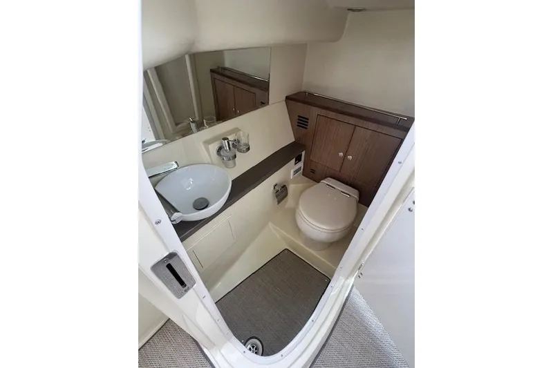 Slide: The Image of 2021 Chris-Craft Launch 35 GT boat bathroom with sink, toilet, and wooden cabinetry. - 33