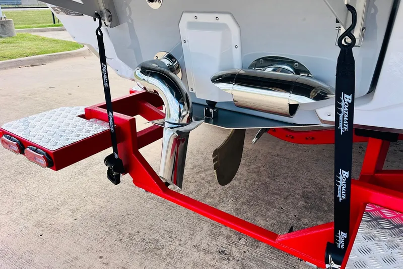 Slide: The Image of 2026 Nautique Super Air Nautique G25 boat trailer with red frame and chrome exhaust. - 11