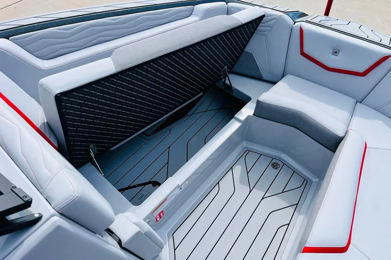 Slide: The Image of 2026 Nautique Super Air Nautique G25 interior seating with storage compartment open. - 22