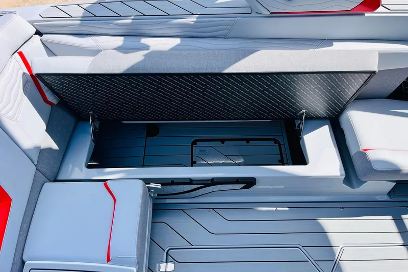 Slide: The Image of 2026 Nautique Super Air Nautique G25 interior storage compartment with sleek gray and red seating. - 43