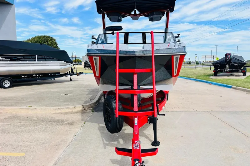 Slide: The Image of 2026 Nautique Super Air Nautique G25 boat on a red trailer in a parking lot. - 5