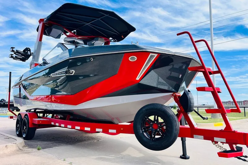 Slide: The Image of 2026 Nautique Super Air Nautique G25 boat on red trailer under blue sky. - 6