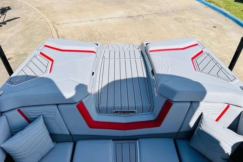 Slide: The Image of 2026 Nautique Super Air Nautique G25 boat interior with sleek gray and red upholstery. - 69