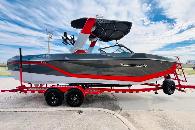 Slide: The Image of 2026 Nautique Super Air Nautique G25 boat on a red trailer under a blue sky. - 7