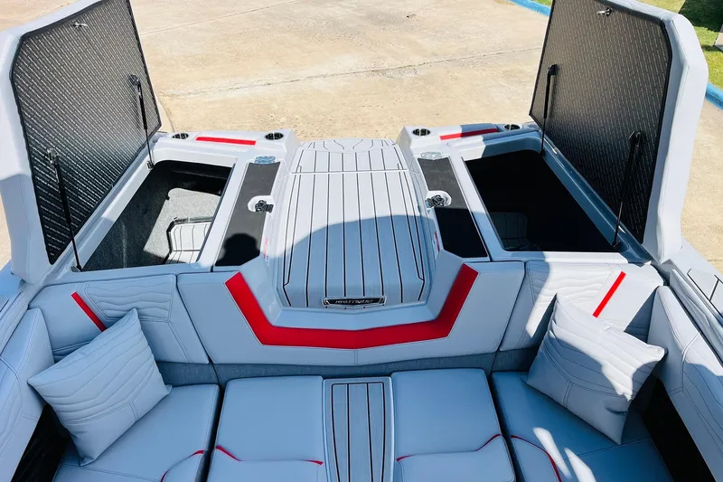 Slide: The Image of 2026 Nautique Super Air Nautique G25 interior with open storage compartments and cushioned seating. - 72