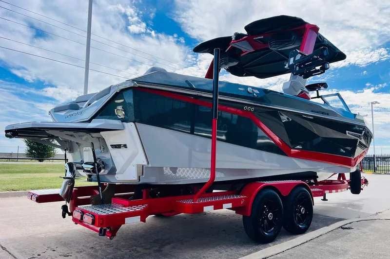 Slide: The Image of 2026 Nautique Super Air Nautique G25 boat on red trailer under blue sky. - 8