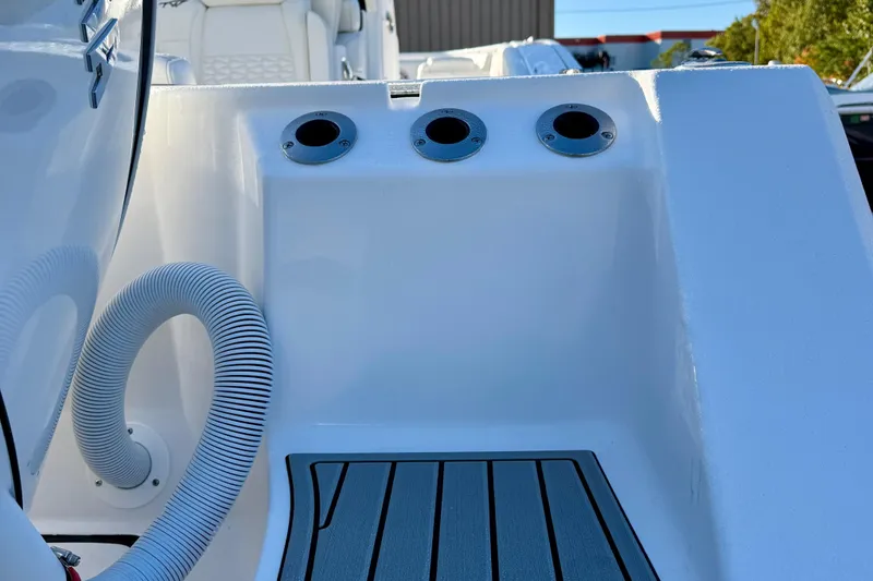 Slide: The Image of 2026 Tidewater 282 CC Adventure boat deck with rod holders and hose. - 14