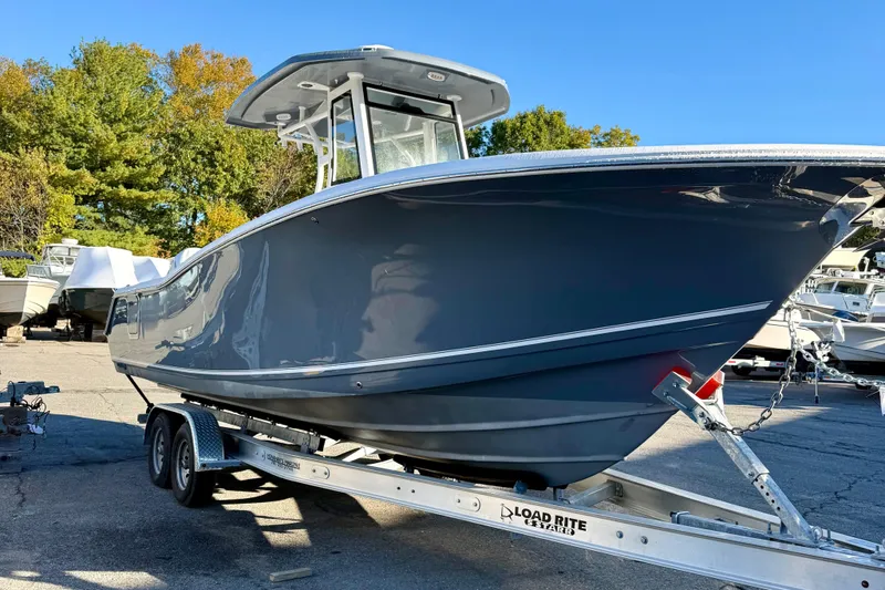 Slide: The Image of 2026 Tidewater 282 CC Adventure boat on trailer, parked outdoors. - 2